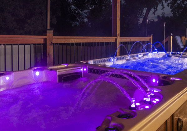 Purple-lit spas with fountains at night